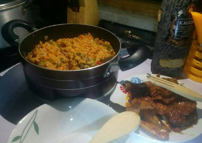 Jollof rice with veggies with peppered chicken and goat meat