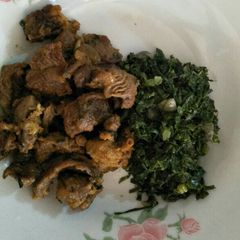 A picture of Fried beef with greens.