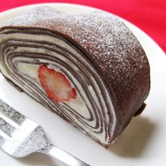 A picture of Cocoa Crepe Roll Cake with Whole Strawberries.