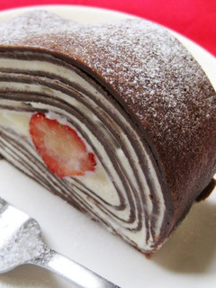 A picture of Cocoa Crepe Roll Cake with Whole Strawberries.