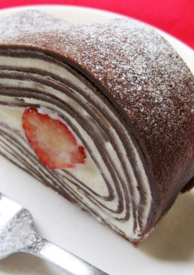 A picture of Cocoa Crepe Roll Cake with Whole Strawberries.
