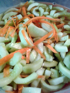 A picture of cucumbers and carrots in vinegar.