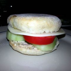 A picture of Taisen's english muffin w/tomato, cucumber, cheese and dressing.