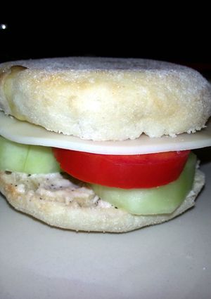 A picture of Taisen's english muffin w/tomato, cucumber, cheese and dressing.