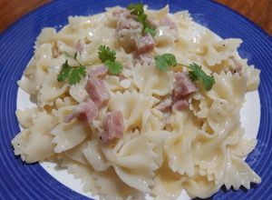 Una foto de Pasta farfalle en salsa blanca con jamón y queso