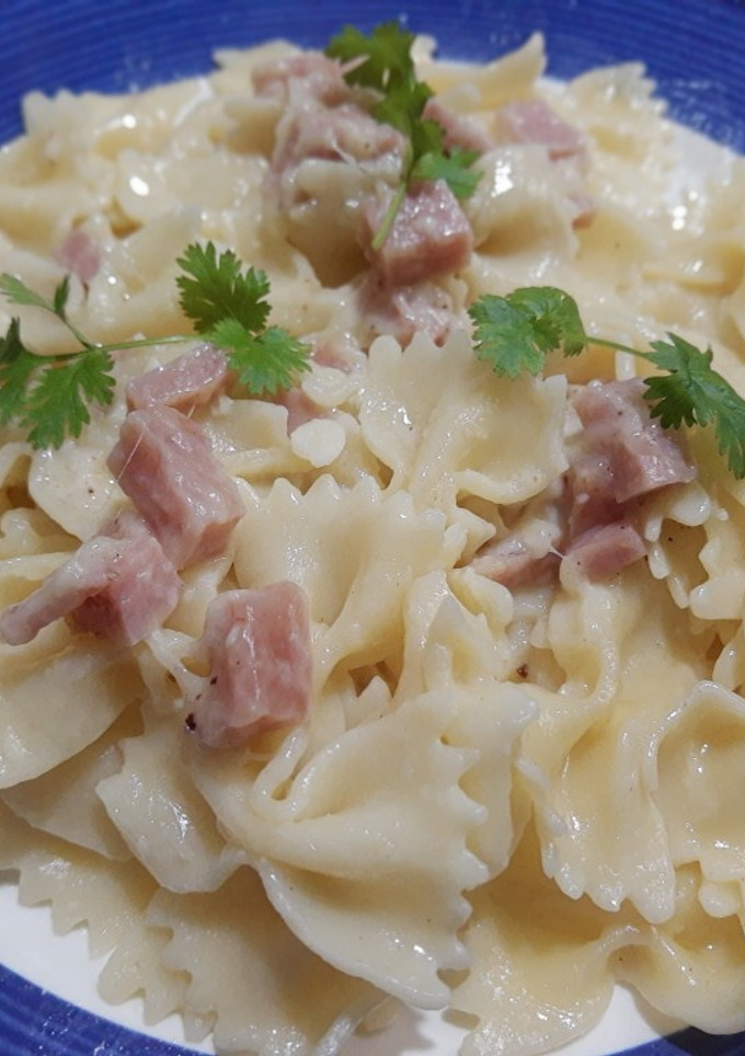 Una foto de Pasta farfalle en salsa blanca con jamón y queso