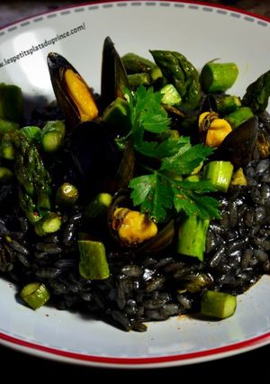 Une photo de Risotto à l'encre de seiche, moules et asperges vertes