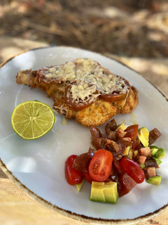 Una foto de Milanesas tipo caprese con parmesano y ensalada de aguacate