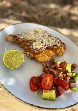 Una foto de Milanesas tipo caprese con parmesano y ensalada de aguacate
