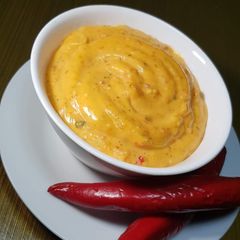 A picture of Yellow sauce with fried items.