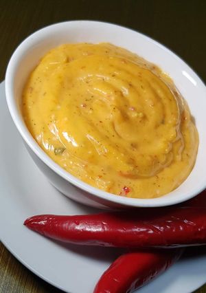 A picture of Yellow sauce with fried items.
