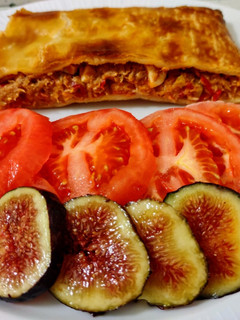 Una foto de Empanada de atún con ensalada de tomates, higos y pepinillos