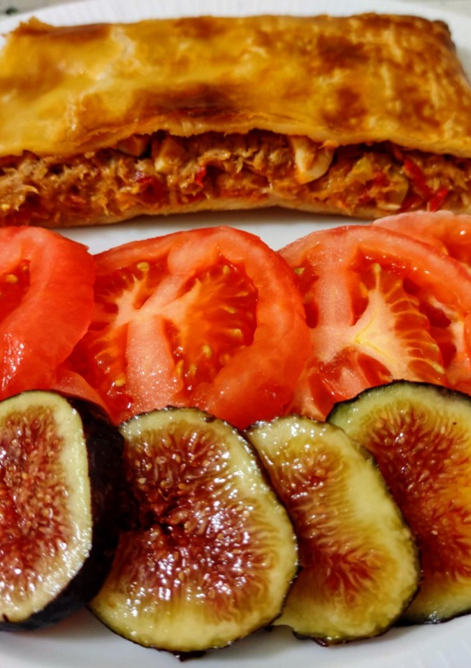 Una foto de Empanada de atún con ensalada de tomates, higos y pepinillos