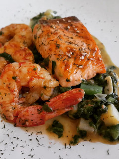 Una foto de Salmón con salsa de espinacas y verduritas con gambas
