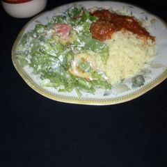 A picture of Rice and beef stew with salad.
