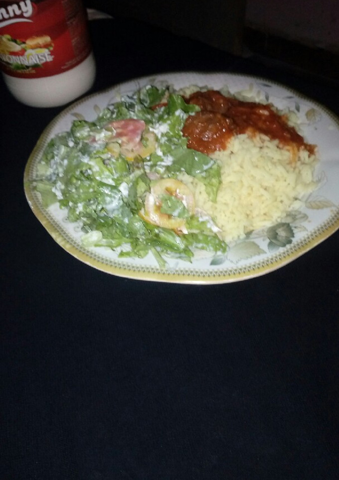 A picture of Rice and beef stew with salad.
