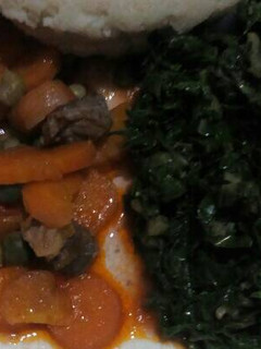 A picture of Ugali with beef stew and fried spinach.