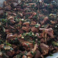A picture of Fried pork with greens.