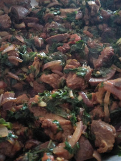 A picture of Fried pork with greens.