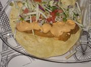 Una foto de taco de pescado con cerveza