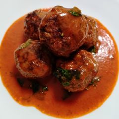 A picture of Meatballs in tomato and coconut sauce.