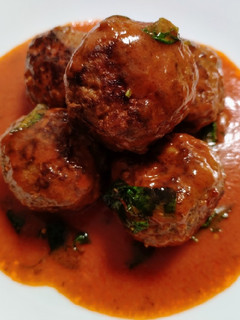 A picture of Meatballs in tomato and coconut sauce.