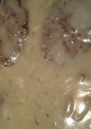 A picture of grilled hamburgers smothered in gravy.