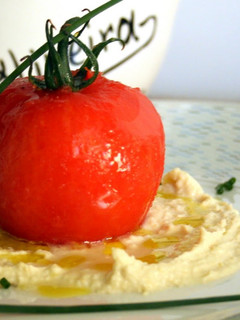 Una foto de Tomate relleno de bacalao al Pil Pil sobre humus