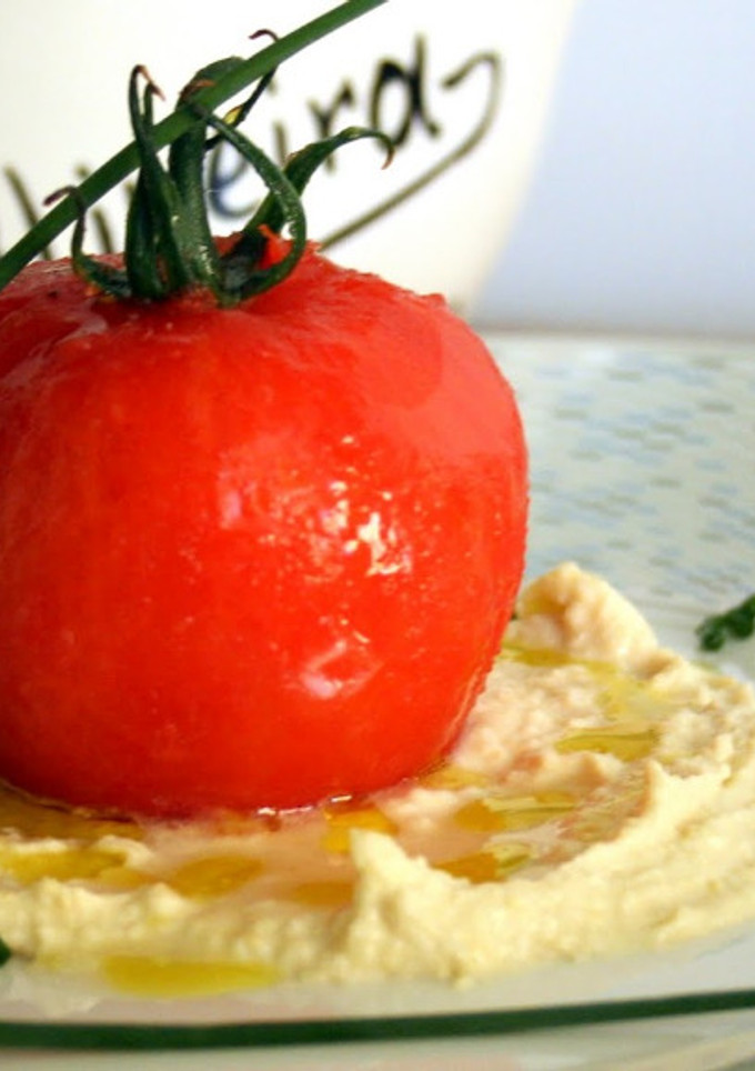 Una foto de Tomate relleno de bacalao al Pil Pil sobre humus