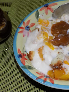 Una foto de Postre de pan dulce, budín con duraznos en almíbar y yogur