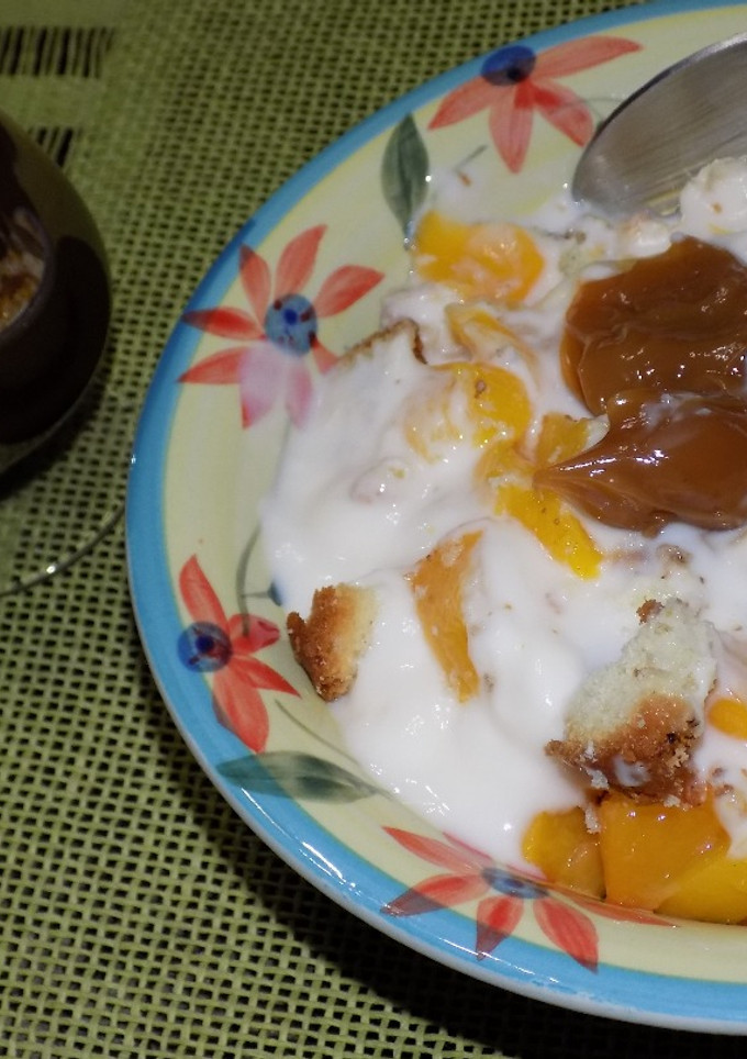 Una foto de Postre de pan dulce, budín con duraznos en almíbar y yogur