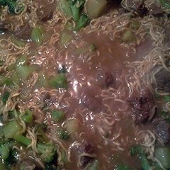 A picture of instant noodles with steak and broccoli.