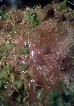 A picture of instant noodles with steak and broccoli.