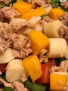 Una foto de Ensalada de rúcula, mango, palmitos, atún y tomate. Con vinagreta agridulce
