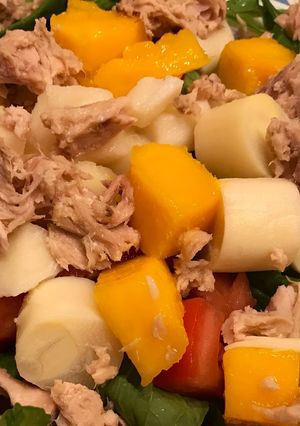 Una foto de Ensalada de rúcula, mango, palmitos, atún y tomate. Con vinagreta agridulce