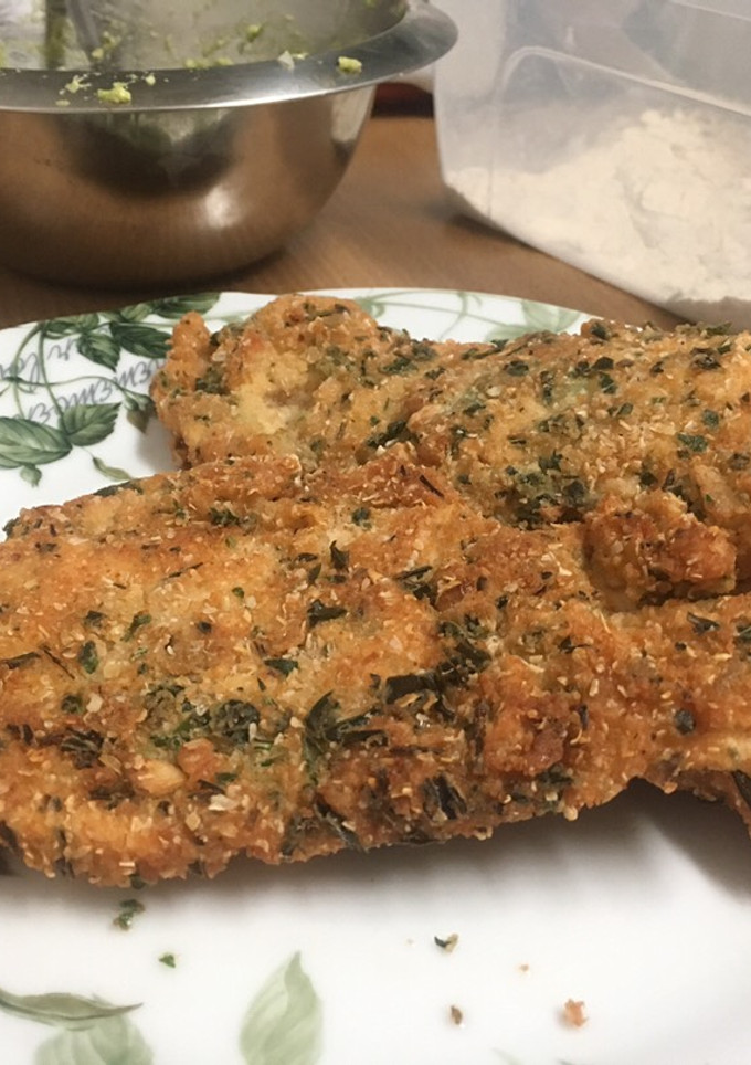 Una foto de Pollo empanado con ajo y rúcula