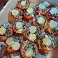 A picture of Roast tomatoes with olives, capers, cheese and sausage.