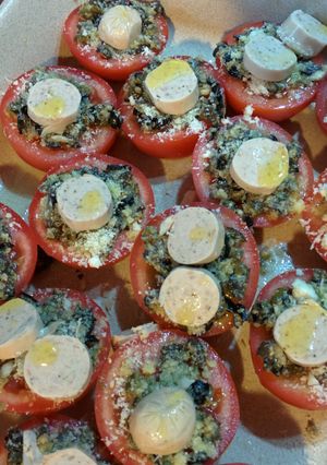 A picture of Roast tomatoes with olives, capers, cheese and sausage.