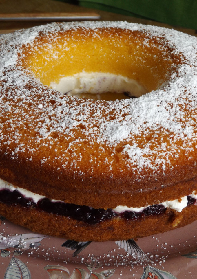 Una foto de Savarín de maíz con relleno de cerezas y arándanos con nata
