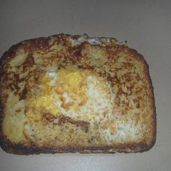 A picture of French toast with an egg in the middle..
