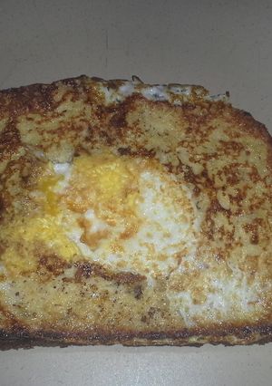 A picture of French toast with an egg in the middle..