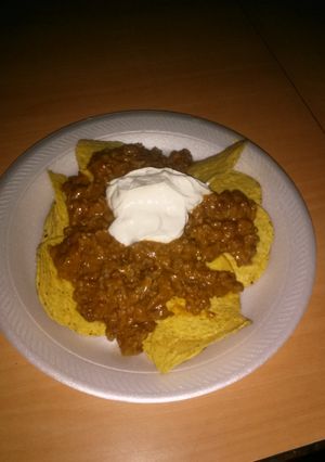 A picture of Beef chilli beans nachos w sour cream bomb AF!.