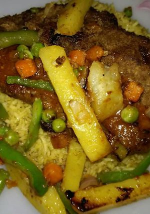 A picture of Beef Steak served with grilled veggies,sauce & Vegetables rice🔥.