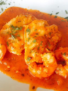 Una foto de Bacalao con salsa de tomate y langostino