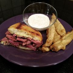 A picture of New York Deli Pastrami Kinishwich with Fried Pickles & Spicy Ranch Dip.