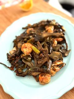 Una foto de Alcachofas con ajos tiernos y gambones