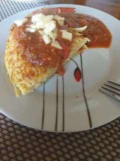Una foto de Tortilla de tallarines acompañada con salsa