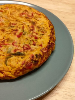 Una foto de Tortilla de patata con pimiento rojo y verde pochado