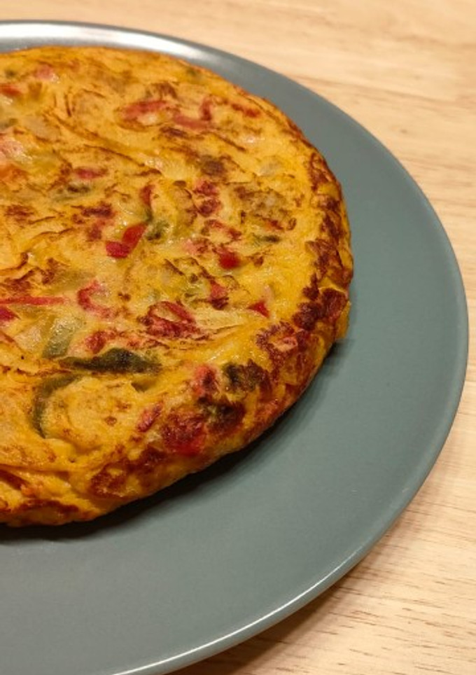 Una foto de Tortilla de patata con pimiento rojo y verde pochado