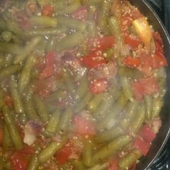 A picture of Green beans with tomato and bacon.